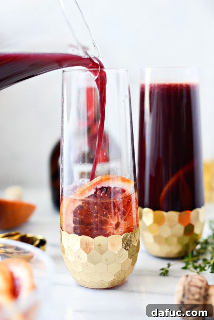 Velvet Vanilla Blood Orange Mimosas 11 Vanilla blood orange juice being poured into a mimosa glass