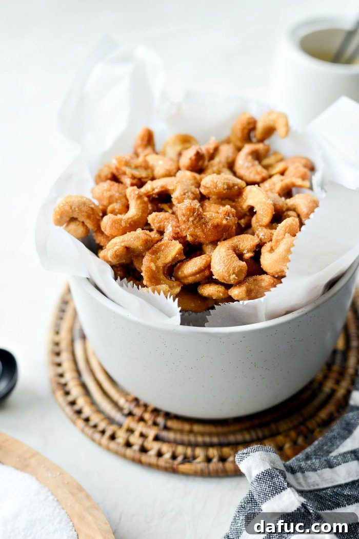 Decadent Honey Roasted Cashews 13 Cooled honey roasted cashews spread on parchment paper on a baking sheet.