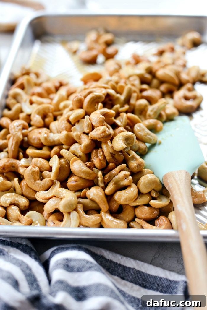 Decadent Honey Roasted Cashews 8 Tossing cashews with a spatula to coat them evenly with the glaze.