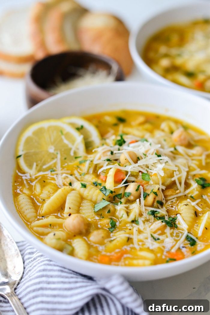 Sunshine Chickpea Bowl 17 A pristine white bowl filled with the inviting golden hues of Lemon Chickpea Soup, showcasing its delightful texture and garnishes.