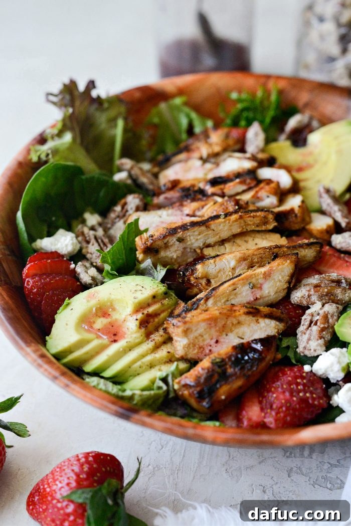 side shot of Strawberry Goat Cheese Spring Salad in a bowl, highlighting its layered presentation