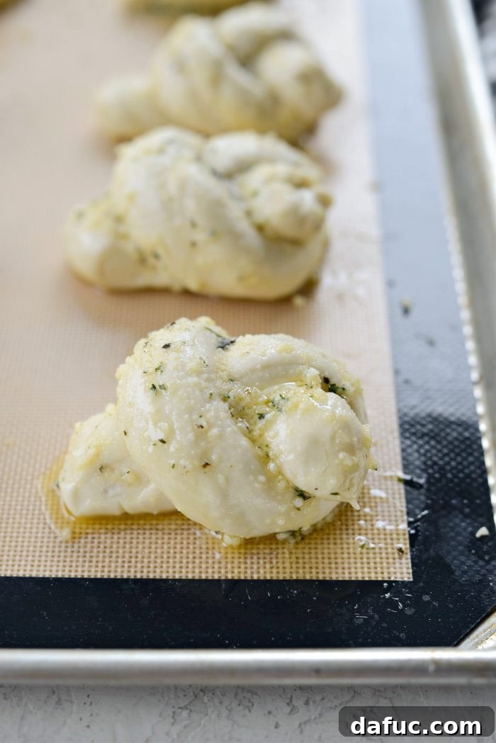 Dough knots fully coated in garlic parmesan herb butter, ready for the oven