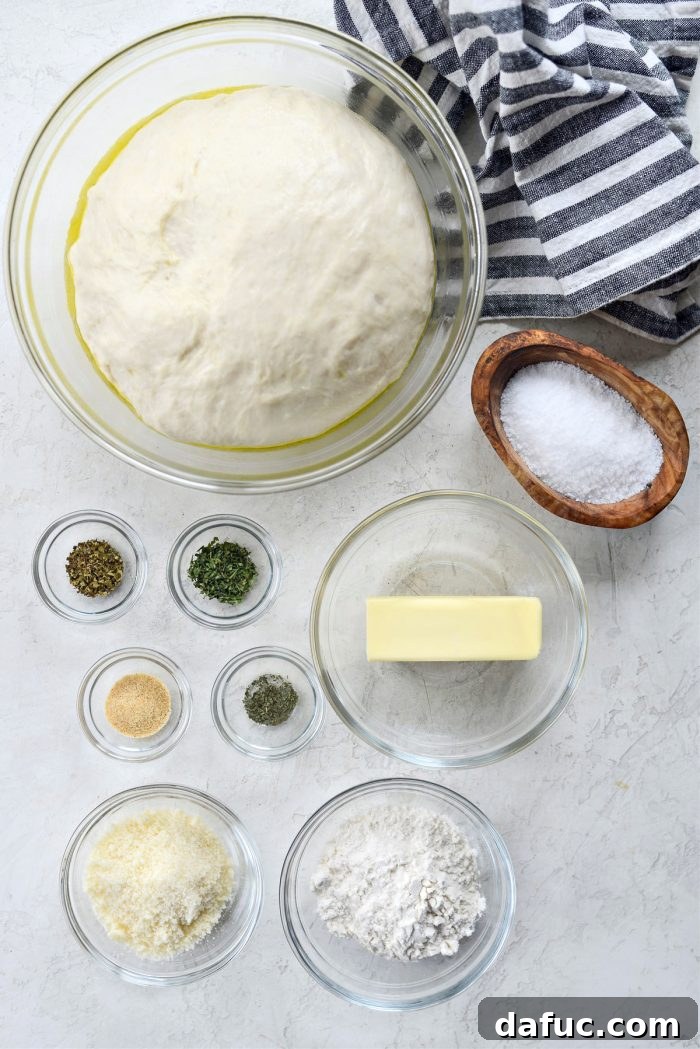 Array of ingredients for homemade garlic herb knots including flour, butter, parmesan, and dried herbs