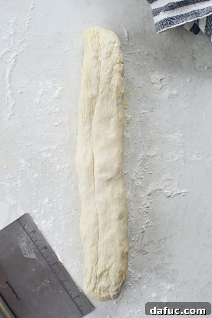 Stretching pizza dough into a log shape