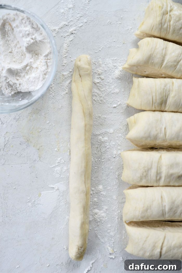 Rolling a piece of dough into a 6 to 8 inch rope