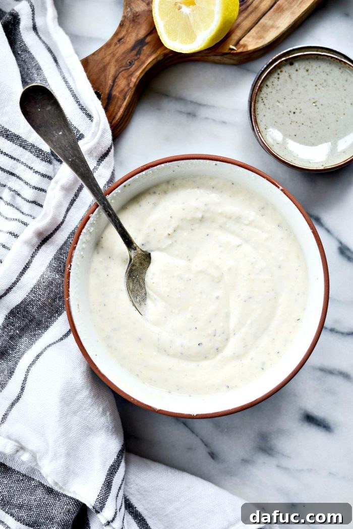 Greek Yogurt Caesar Salad Dressing with a spoon, highlighting a healthy dressing option.