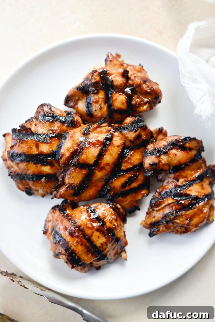 A platter filled with perfectly grilled and glazed Huli Huli chicken, ready for slicing