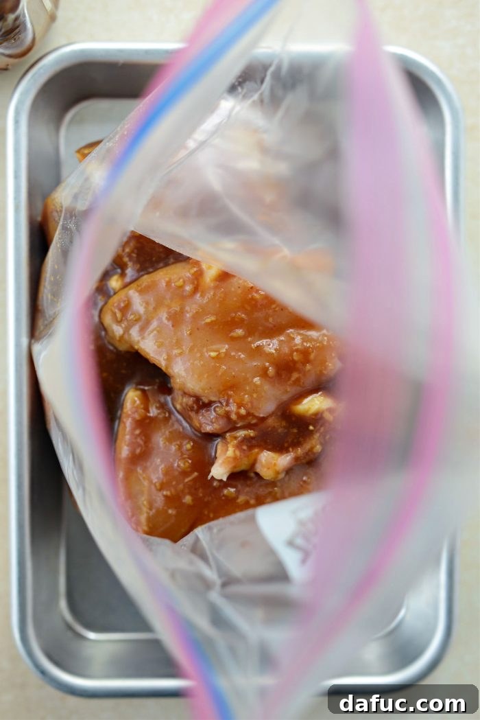 Pouring the remaining Huli Huli marinade over the chicken thighs in the bag