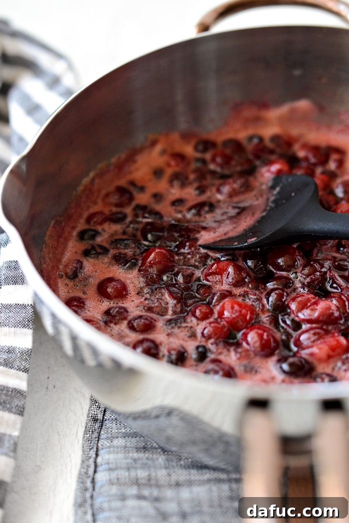 cranberries bursting in the saucepan, ready for mashing