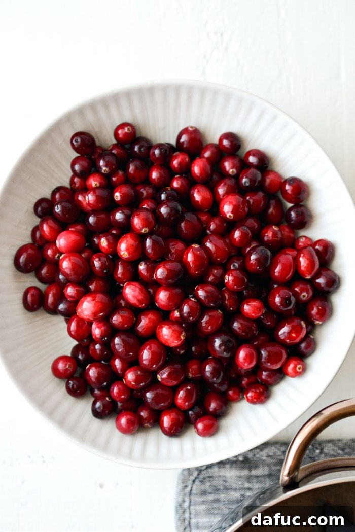 a white bowl filled with fresh, bright red cranberries