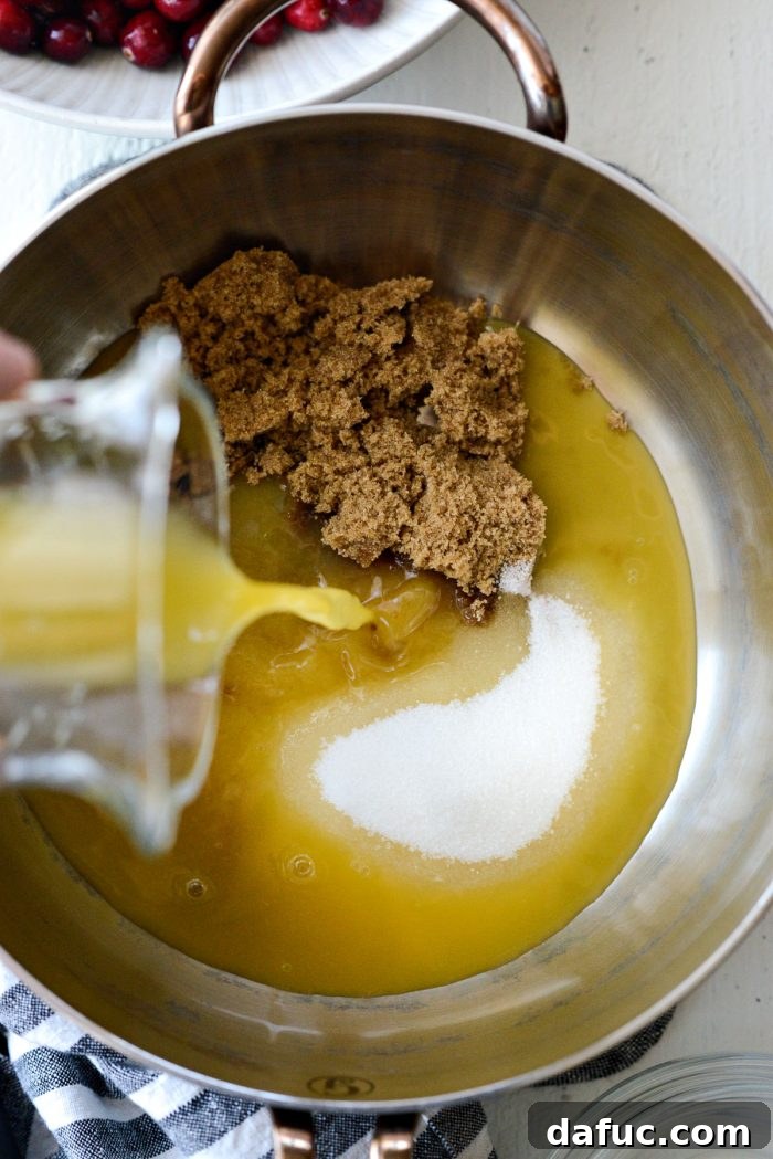 saucepan with granulated and brown sugar, water and orange juice added