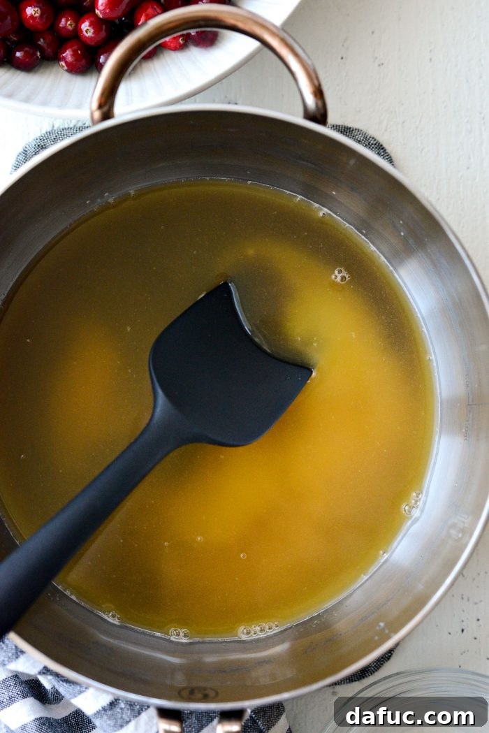 sugar and orange juice combined in a saucepan, beginning to dissolve