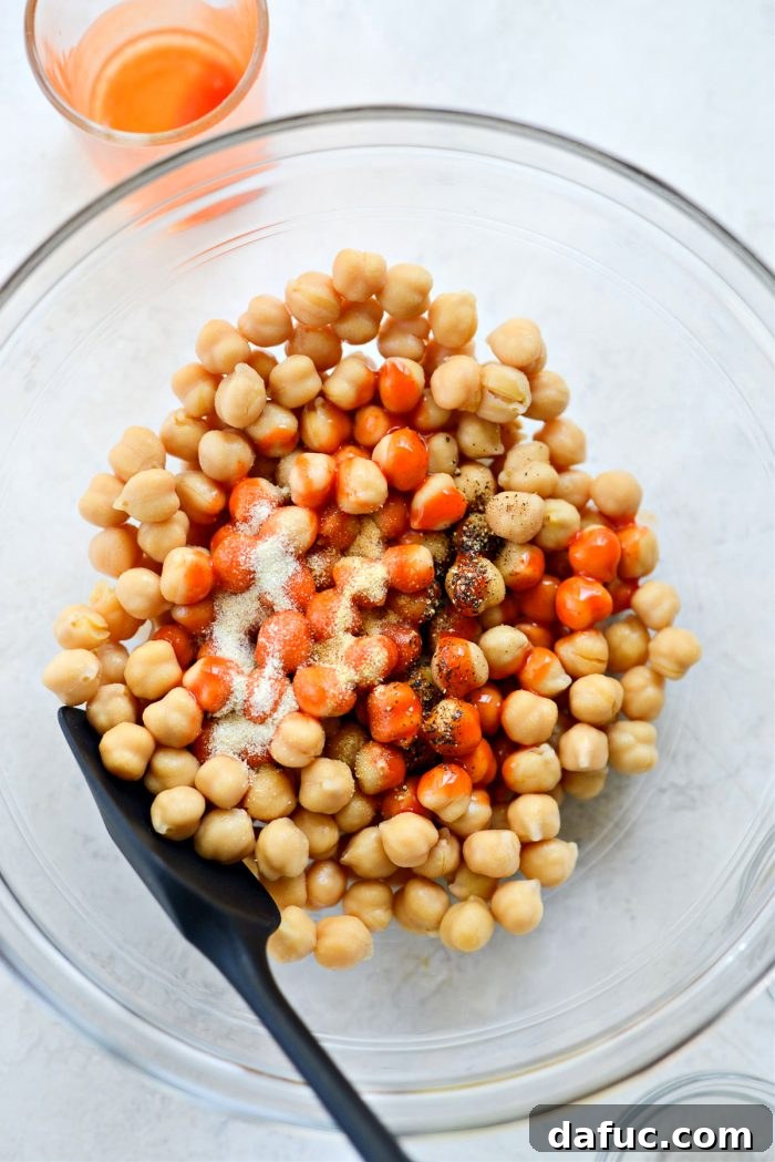 Seasoning chickpeas with garlic powder, onion powder, and black pepper
