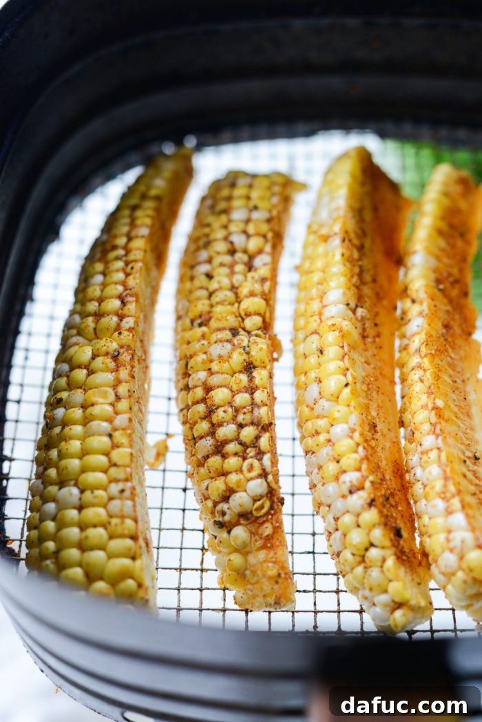 Seasoned corn wedges placed in an air fryer basket