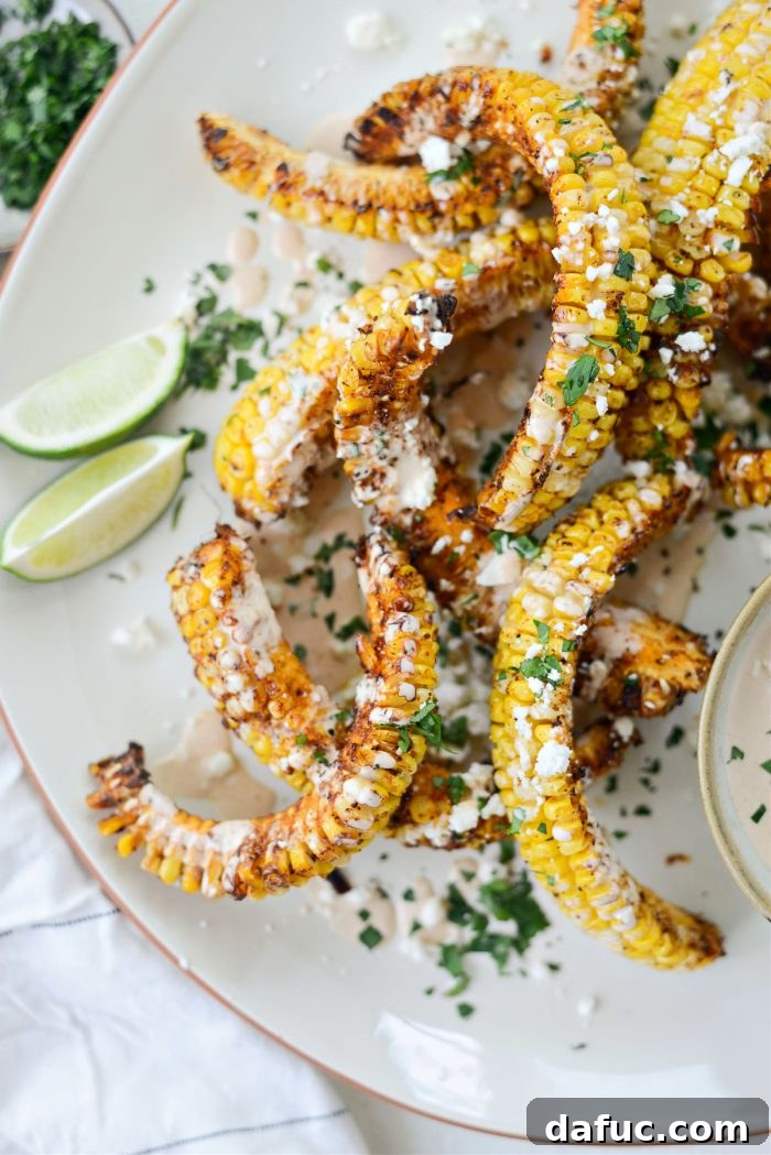 Close-up of Air Fryer Corn Ribs with adobo crema, cilantro, and queso fresco