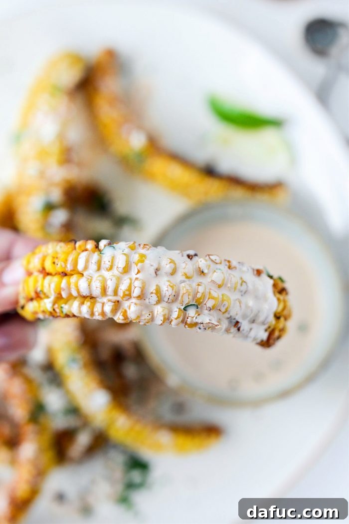 Hand holding a dipped Air Fryer Corn Rib