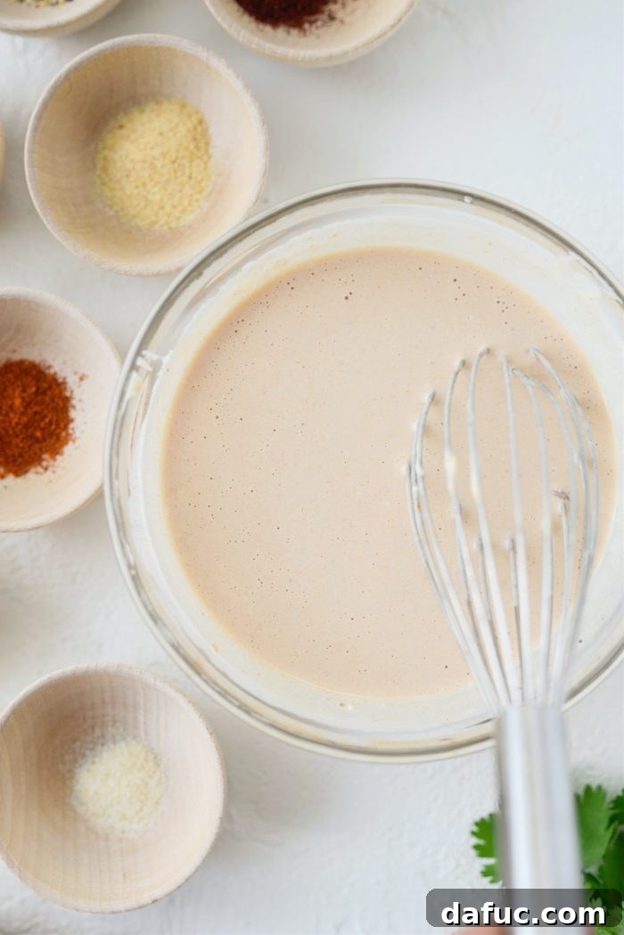 Lime juice being added to the adobo crema mixture, followed by whisking