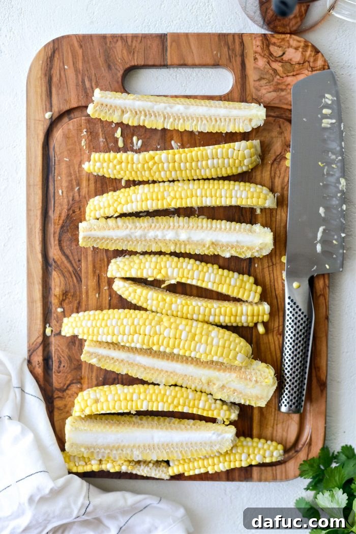 Quartered ears of corn arranged on a cutting board