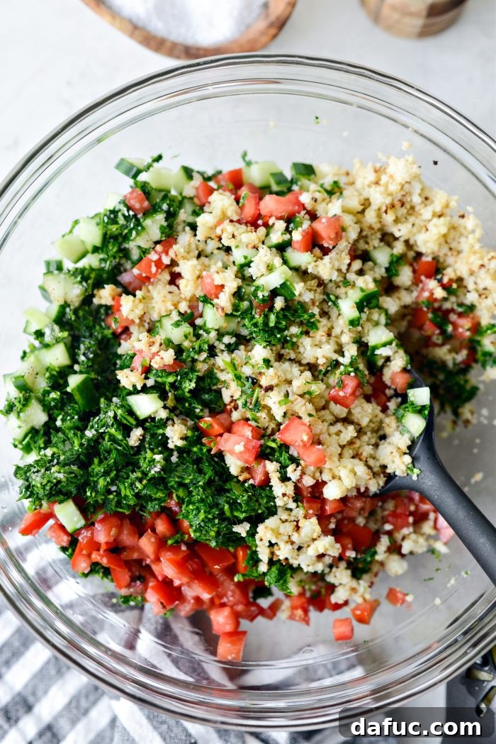 Golden Roasted Cauliflower Tabbouleh 14 Tossing the Roasted Cauliflower Tabbouleh to combine ingredients