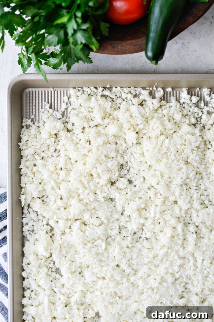 Golden Roasted Cauliflower Tabbouleh 6 Cauliflower rice spread on a sheet pan for roasting