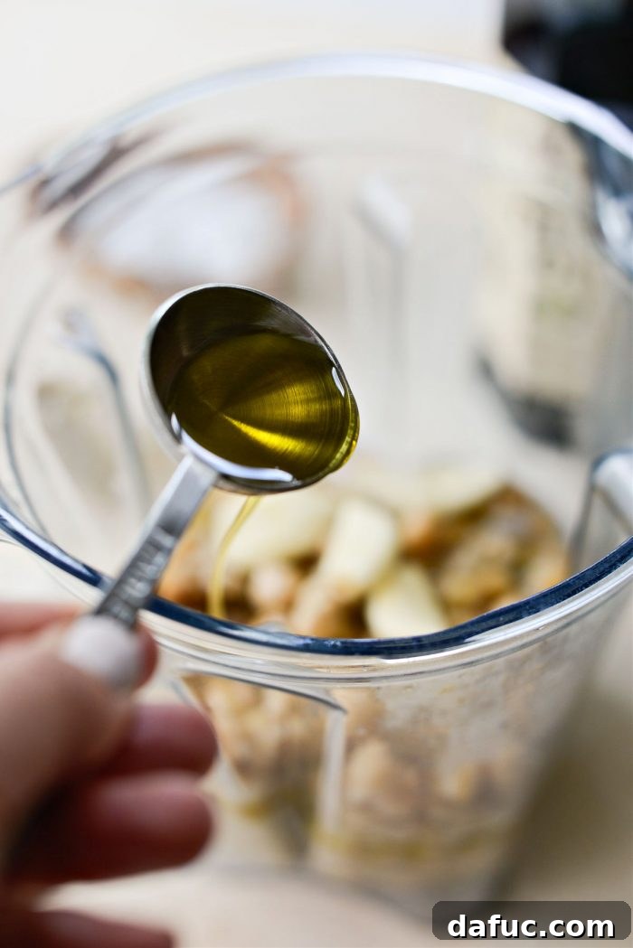 Velvet Smooth Blender Hummus 11 Drizzling olive oil into the blender