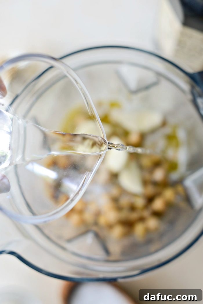 Velvet Smooth Blender Hummus 13 Adding water to hummus ingredients in a blender