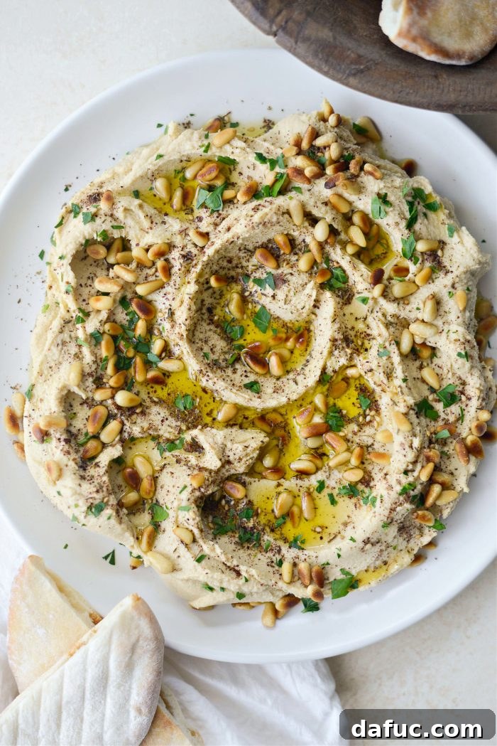 Velvet Smooth Blender Hummus 15 Creamy hummus garnished with olive oil, pine nuts, and parsley, served with roasted cauliflower tabbouleh