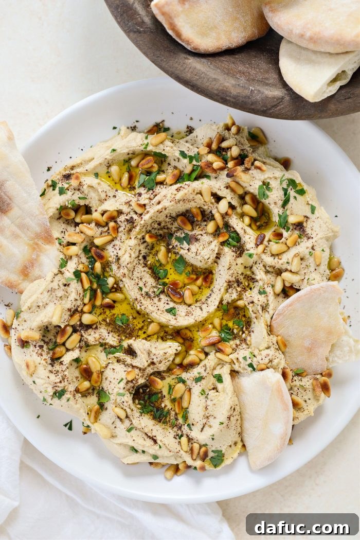 Velvet Smooth Blender Hummus 17 Close-up of creamy hummus with a spoon creating swirls