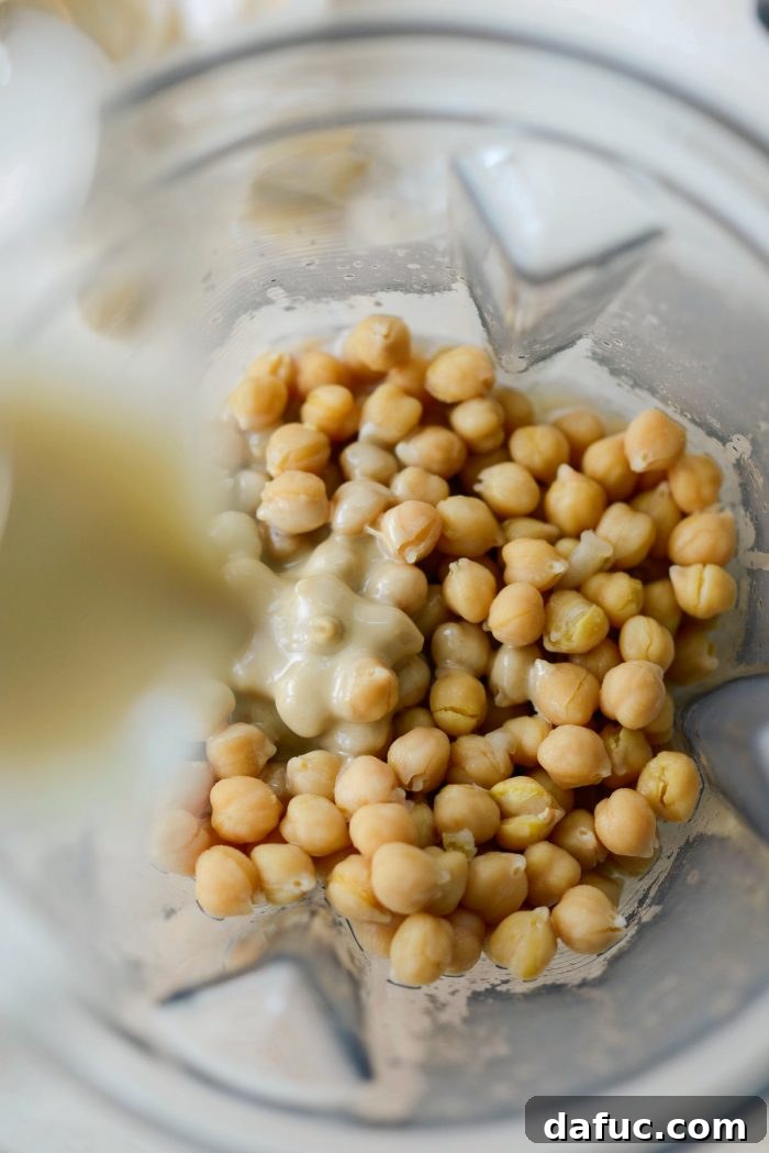 Velvet Smooth Blender Hummus 8 Drained chickpeas and tahini being added to a blender