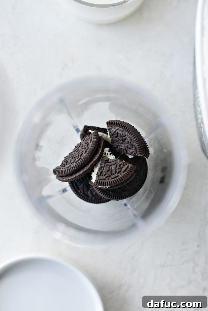 Espresso Cookies and Cream Milkshake 5 Three chocolate sandwich cookies being added to a blender.