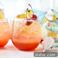Pineapple Tequila Sunrise Shandy cocktail with pineapple slice and cherry garnish