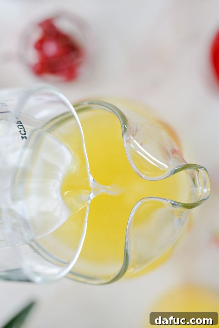 Tropical Tequila Sunrise Shandy 6 Adding tequila blanco to the pineapple juice in the pitcher