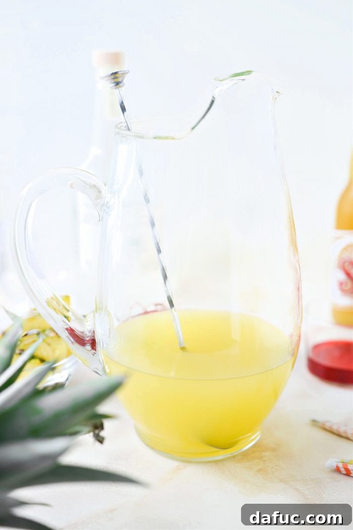 Tropical Tequila Sunrise Shandy 8 Stirring the pineapple, tequila, and simple syrup mixture thoroughly