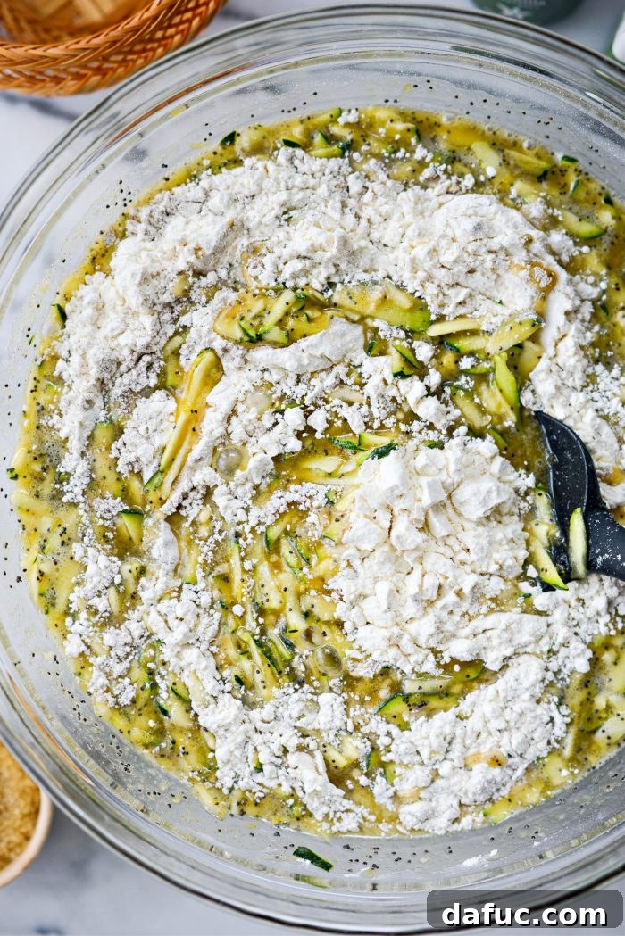 Stirring wet and dry ingredients together with a spatula until just combined
