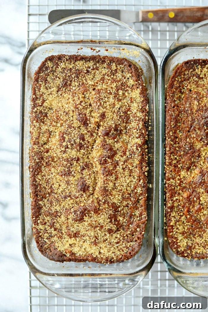 Baked zucchini bread loaves cooling in pans on a wire rack