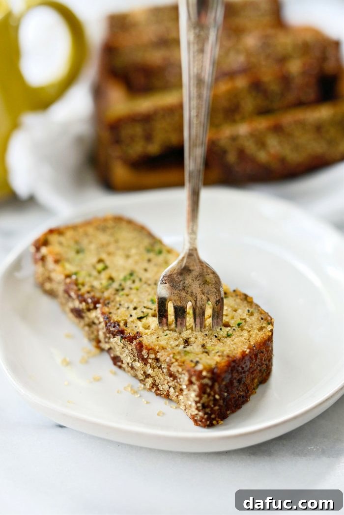 Another beautiful shot of a whole Lemon Poppy Seed Zucchini Bread loaf on a wooden board