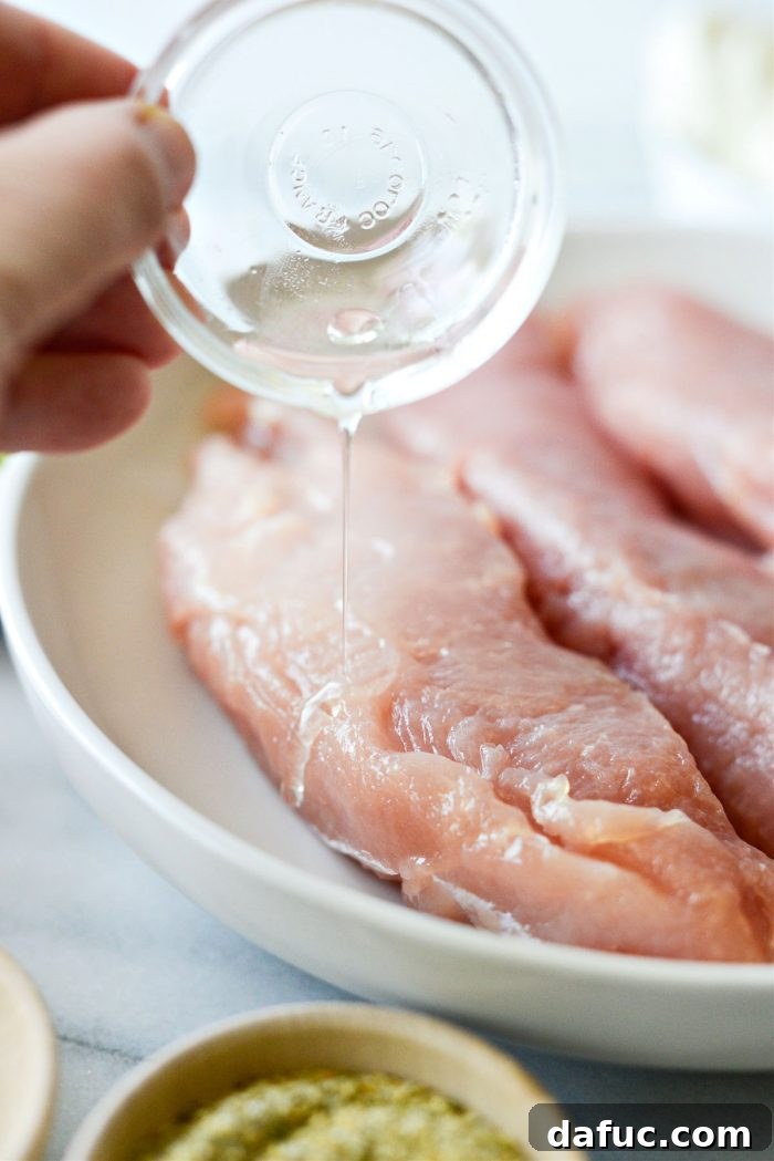 Drizzling olive oil over turkey breast tenderloins