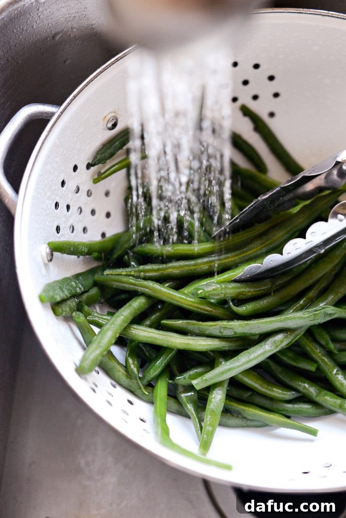 rinsing blanched green beans with cold water.