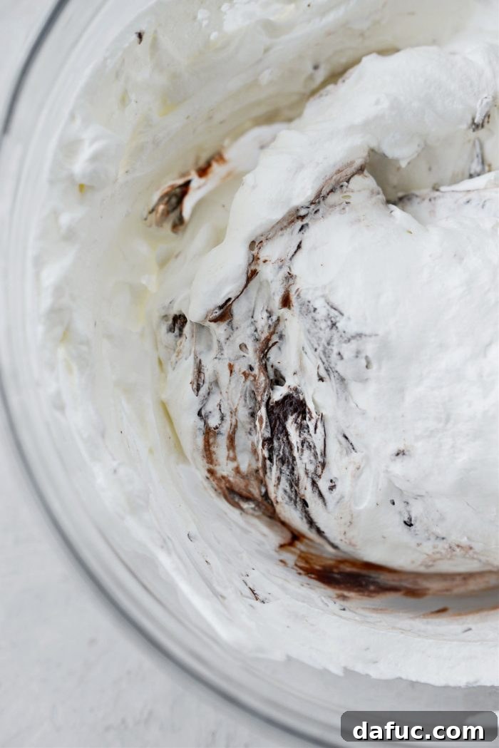 Blissful No-Churn Hash Indulgence 13 Gently folding whipped cream into chocolate mixture with a spatula