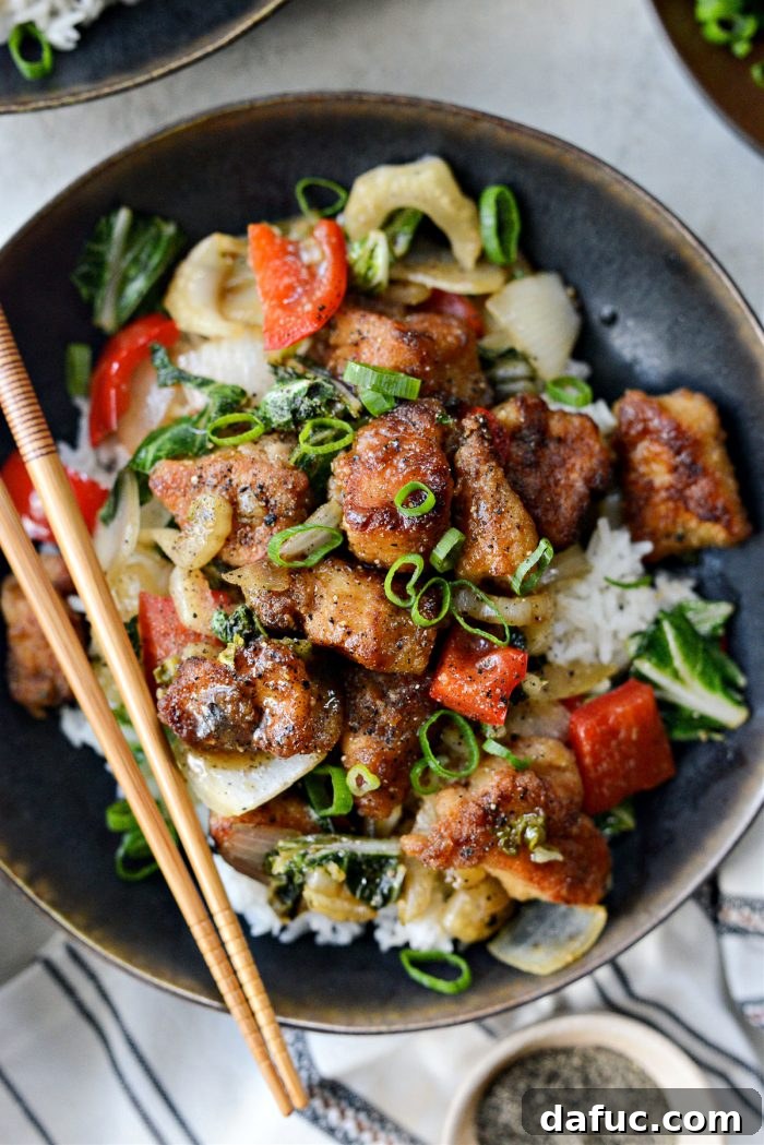 Black Pepper Chicken Stir-fry, served over rice with green onions
