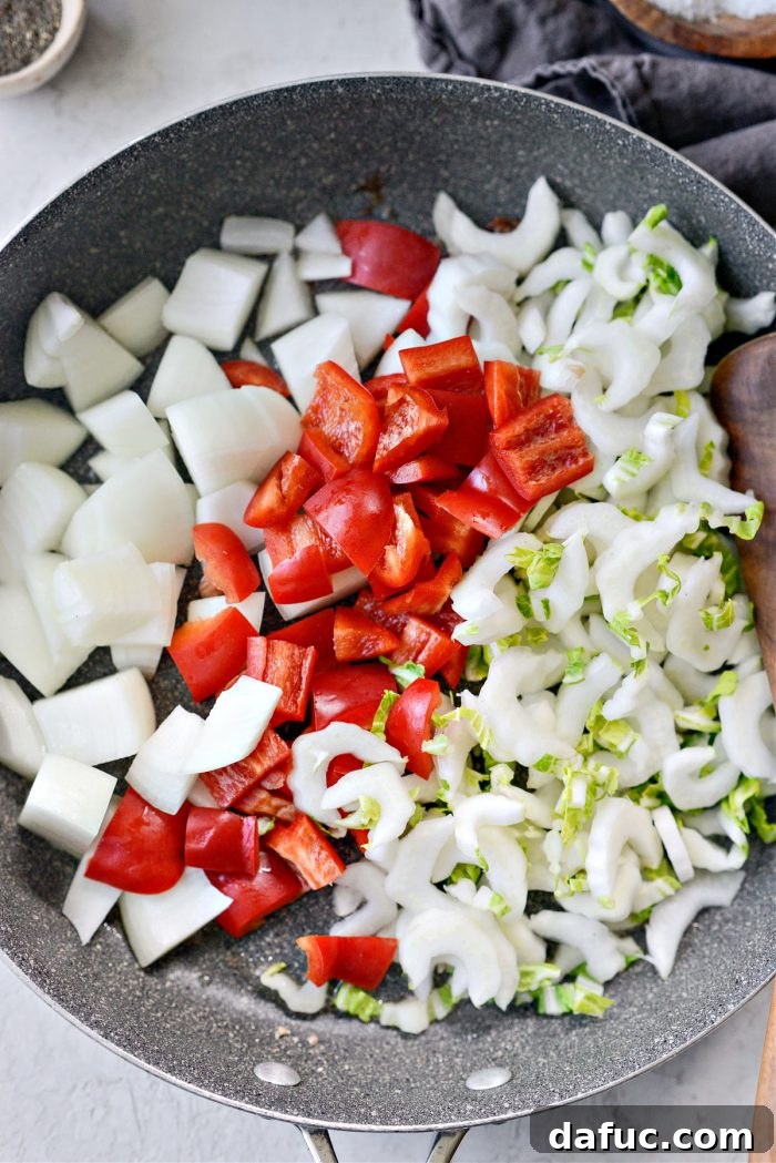 Diced vegetables added to the skillet with residual oil