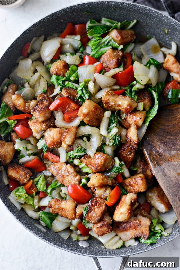 Tossed chicken and vegetables coated in black pepper sauce in a skillet