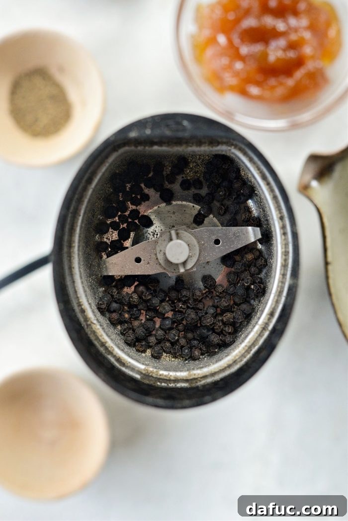 Black peppercorns in a spice grinder