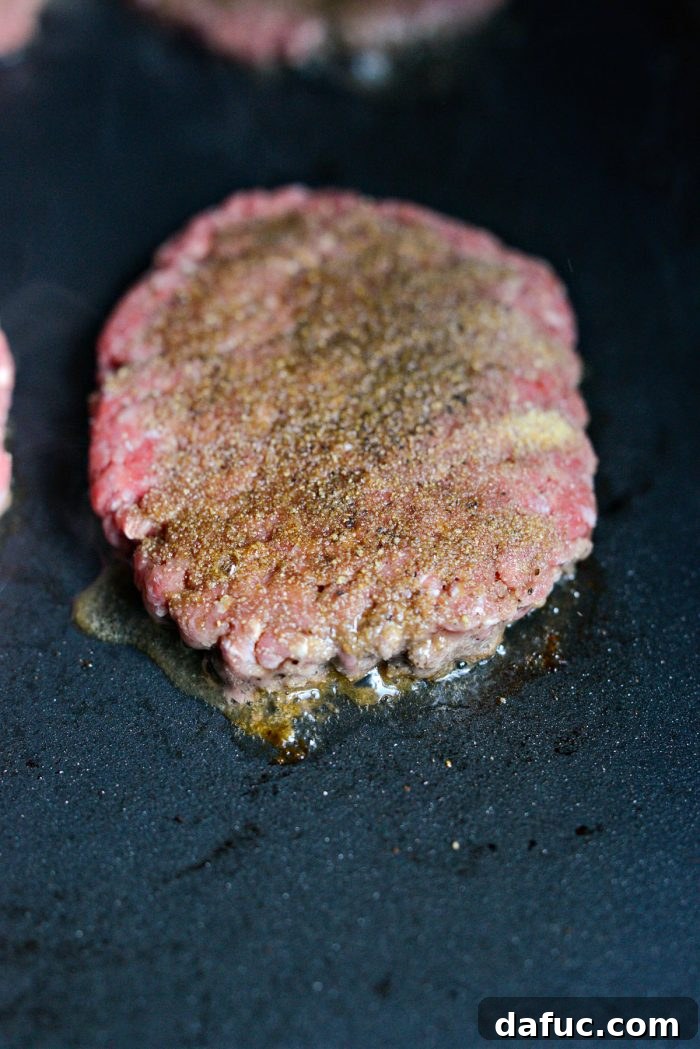The Ultimate Beef Patty Melt 11 Beef patties sizzling loudly on the hot griddle, developing a brown crust