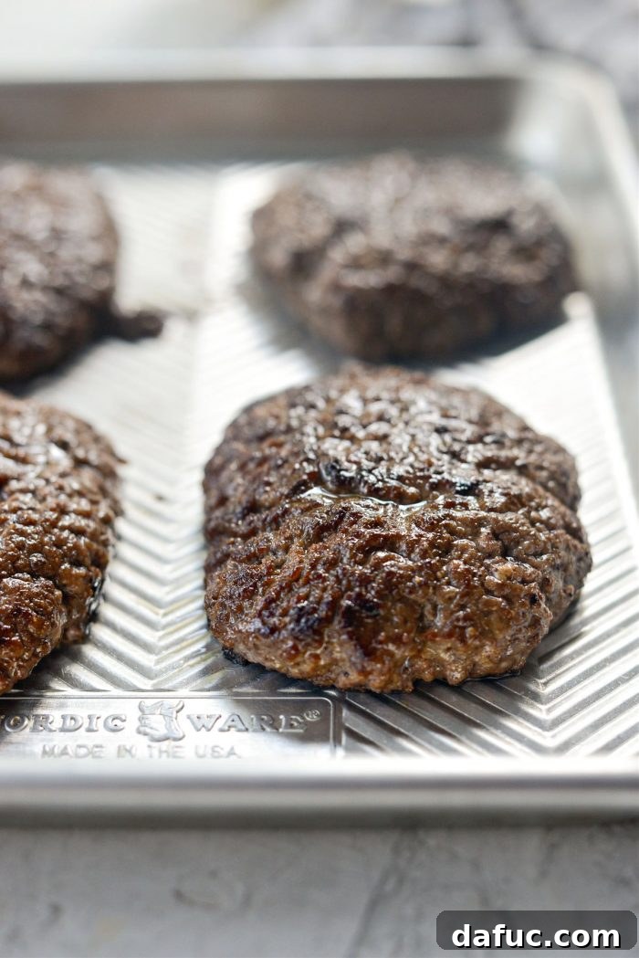 The Ultimate Beef Patty Melt 12 Cooked beef patties resting on a platter, covered with foil to keep warm