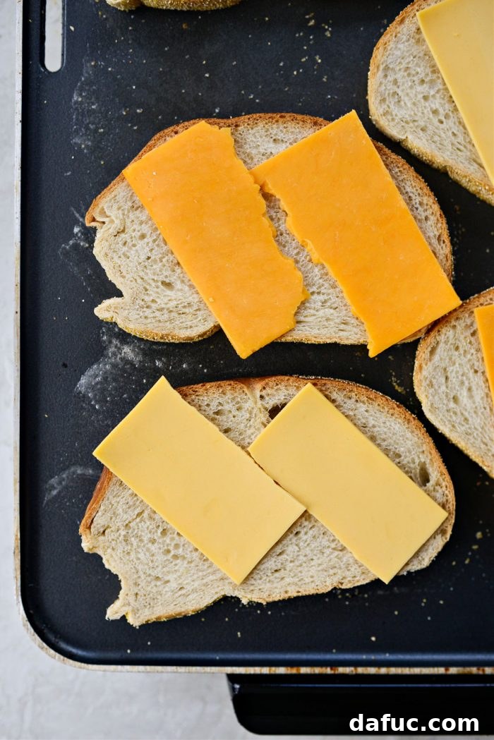 The Ultimate Beef Patty Melt 14 Rye bread slices with American and cheddar cheese melting on the griddle, beginning to toast