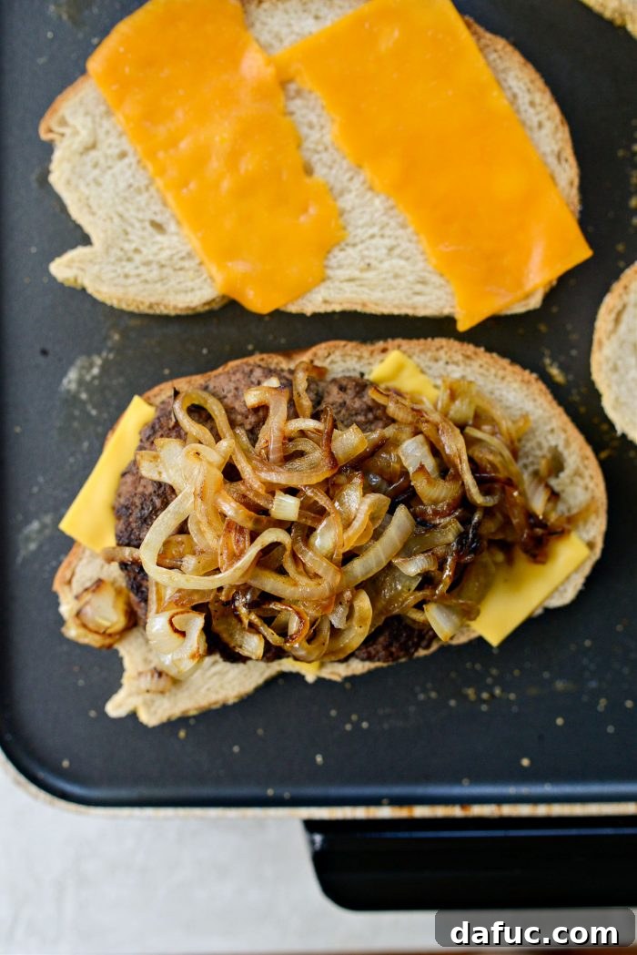 The Ultimate Beef Patty Melt 15 Beef patties and caramelized onions placed on American cheese-topped rye bread slices on the griddle