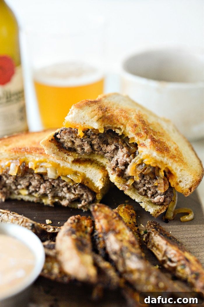 The Ultimate Beef Patty Melt 22 A beautiful close-up shot of a Classic Beef Patty Melt, cut in half, showcasing its inviting layers of filling and golden crust