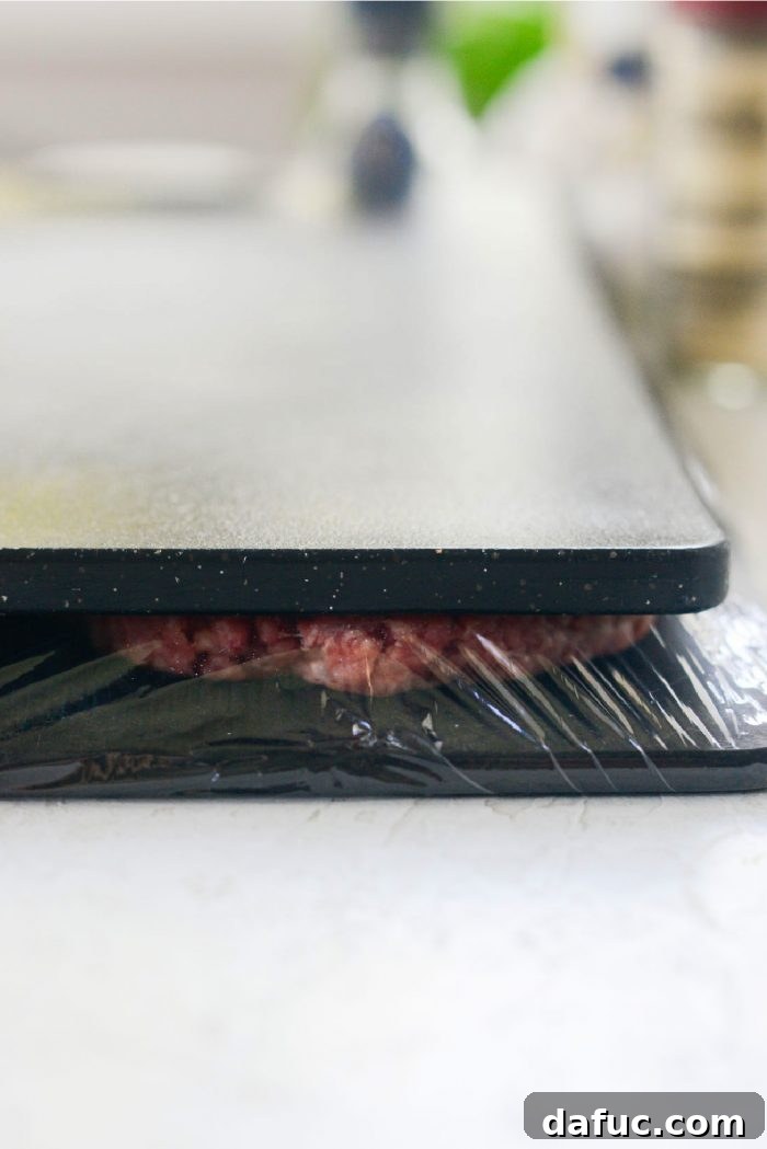 The Ultimate Beef Patty Melt 5 Hands pressing thin ground beef patties between two cutting boards for even thickness