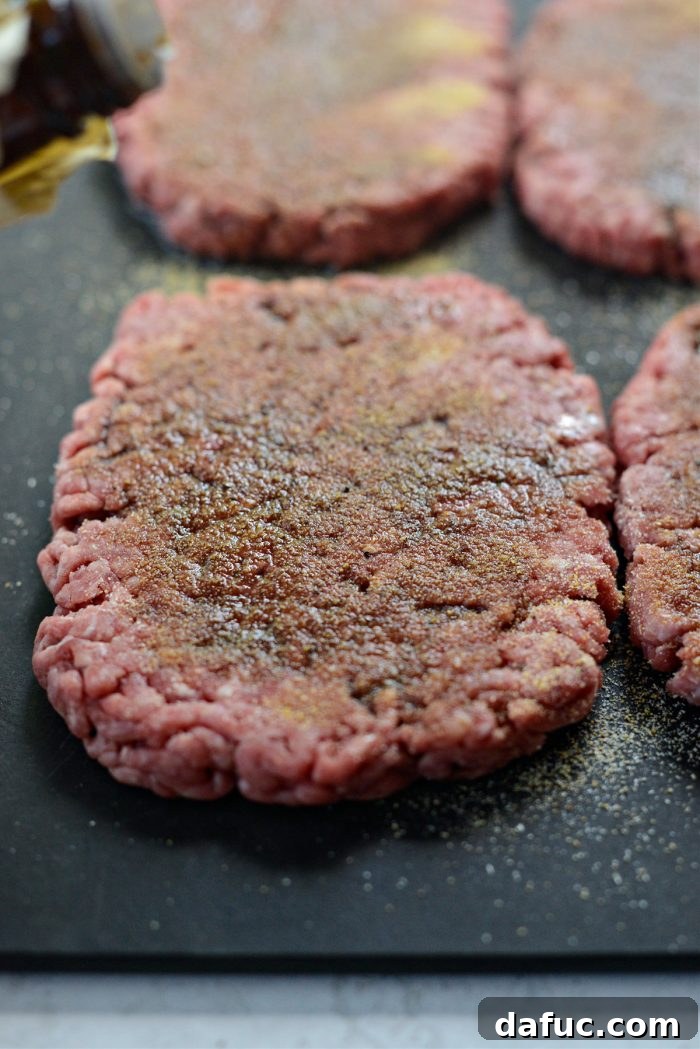 The Ultimate Beef Patty Melt 10 Prepared beef patties on a cutting board, generously seasoned with spices and Worcestershire sauce
